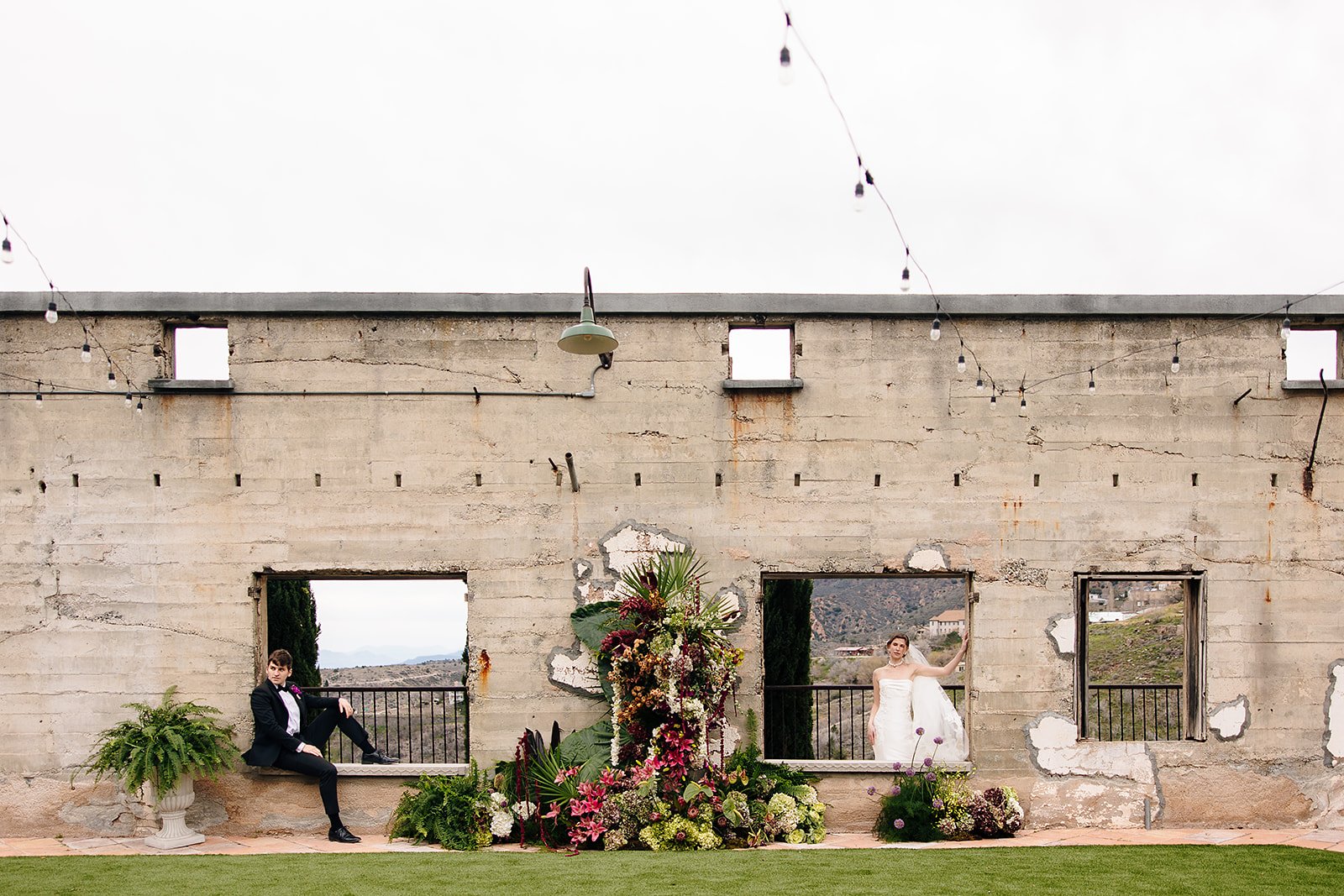 Couple portrait in front of a Mediterranean-style wedding venue with cypress trees