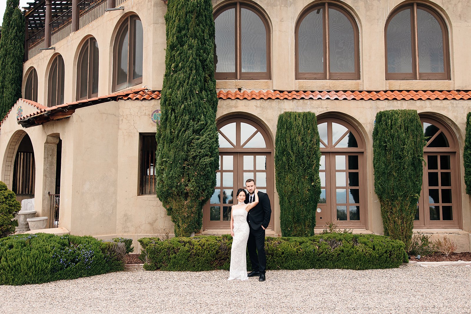 Couple sharing cocktails on the steps of a Spanish-style wedding venue