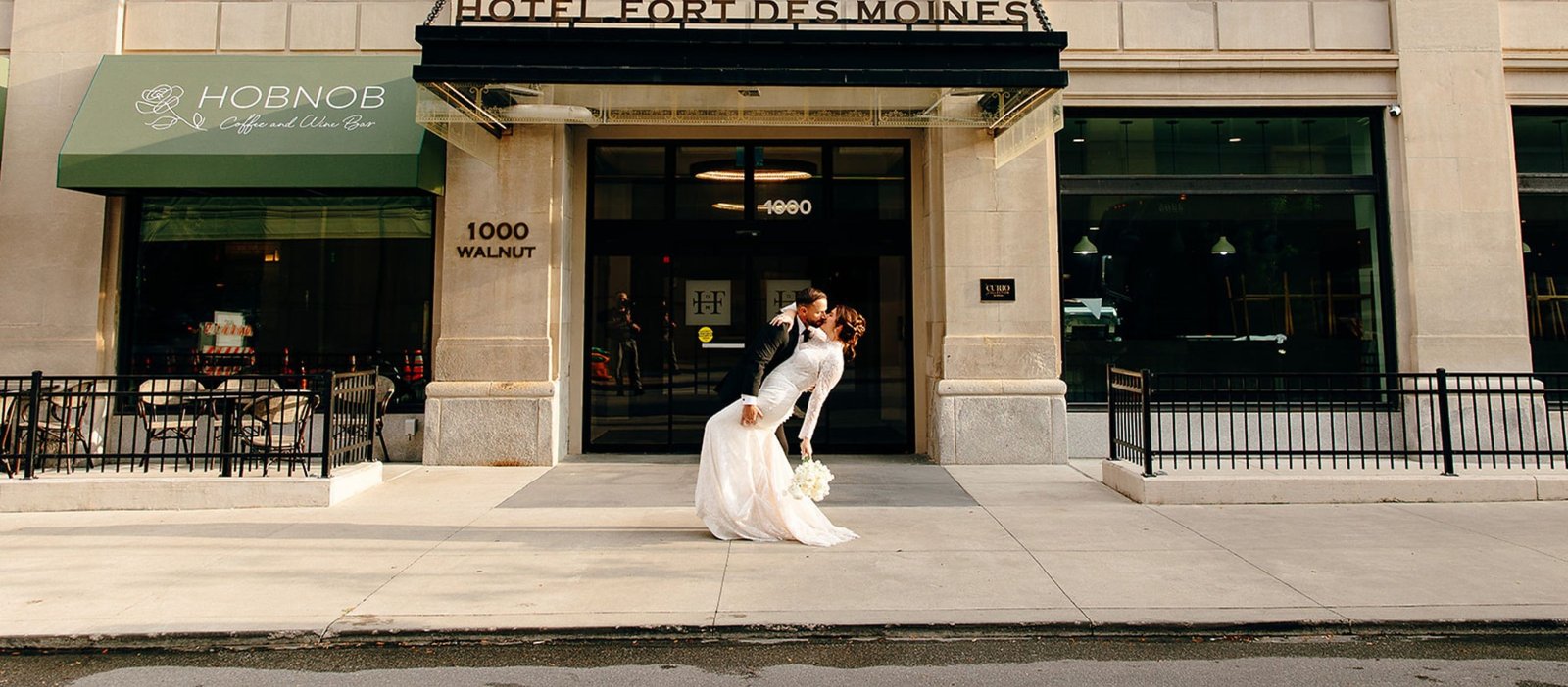 Bride and groom kissing outside Hotel Fort Des Moines