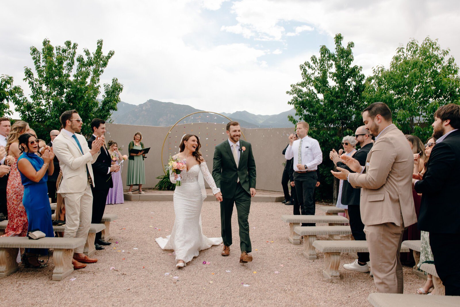 Couple portrait in front of a Mediterranean-style wedding venue with cypress trees