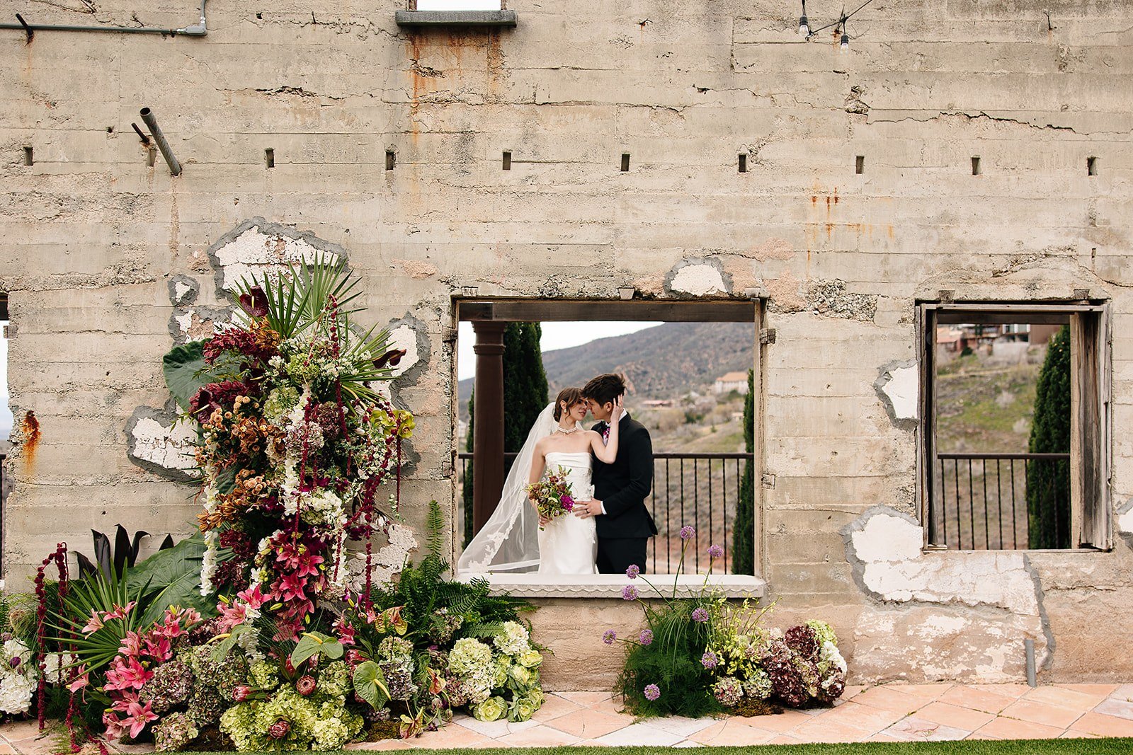 Groom helping a bride with her dress on the stairs